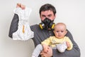 Father with gas mask is holding stinky diaper and little baby Royalty Free Stock Photo
