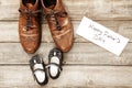 Father and girl brown shoes on wooden background, fathers day Royalty Free Stock Photo