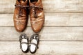 Father and girl brown shoes on wooden background, fathers day Royalty Free Stock Photo