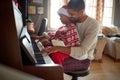 Father with child girl on Christmas morning play music on piano