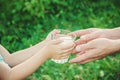 The father gives the child a glass of water.