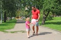 Father gives the child sweet cotton wool while walking in the park. Sweet break