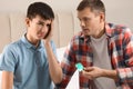 Father giving condom to his teenage son in bedroom. Sex education concept Royalty Free Stock Photo