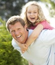 Father giving daughter piggyback Royalty Free Stock Photo