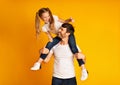 Father Giving His Daughter Piggyback Ride Gesturing Thumbs-Up In Studio Royalty Free Stock Photo
