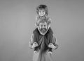 Father giving piggyback ride to his son against a green studio background. Fathers day. Cute child boy hugs his daddy.