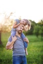 Father giving small daughter a piggyback ride in spring nature. Royalty Free Stock Photo