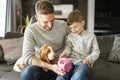 Father or Godfather with Basset dog having fun on the living room At Home puting some money on piggy bank Royalty Free Stock Photo