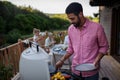 Father grilling meat and vegetable on grill during family summer garden party. Royalty Free Stock Photo