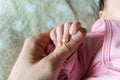 Father hand holds the baby`s hand. Fatherhood concept. closeup view.
