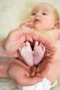Father hands holding small baby's feet