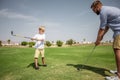 Father has fun and teaches his son to play golf on the green grass Royalty Free Stock Photo