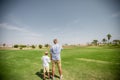 Father has fun and teaches his son to play golf on the green grass Royalty Free Stock Photo