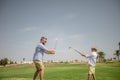 Father has fun and teaches his son to play golf on the green grass Royalty Free Stock Photo