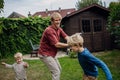 Father having fun with sons in the garden, bonding moment. Concept of Father's Day, and fatherly love. Royalty Free Stock Photo