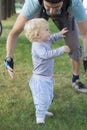 Father hedging their baby, toddler learning to walk Royalty Free Stock Photo