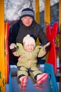 Father helping baby to slide down on playground Royalty Free Stock Photo