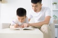 Father helping child doing homework at home