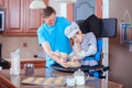 Father helping disabled son bake cookies in kitchen