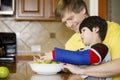 Father helping disabled son in the kitchen Royalty Free Stock Photo