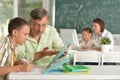 Father helping his son doing homework in classroom Royalty Free Stock Photo