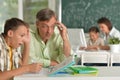 Father helping his son doing homework in classroom Royalty Free Stock Photo