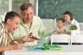 Father helping his son doing homework in classroom Royalty Free Stock Photo