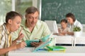 Portrait of father helping his son doing homework in classroom Royalty Free Stock Photo