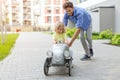 Father helping his son to drive a toy peddle car Royalty Free Stock Photo