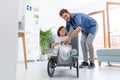 Father helping his son to drive a toy peddle car