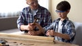 Father helping little cute son at workshop, smart child hammering nail in wood Royalty Free Stock Photo