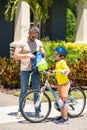 Father helping son get ready for school. Father and son learning to ride a bicycle having fun together at Fathers day Royalty Free Stock Photo
