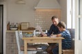 Father Helping Son With Homework Sitting At Kitchen Table Royalty Free Stock Photo