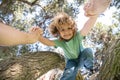 Father helping son to climb tree. Fathers hand. Child protection. Healthy parenting lifestyle.