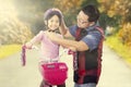 Father helps his daughter to fasten helmet Royalty Free Stock Photo