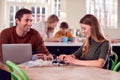 Father Helps Teenage Daughter With Electronics Project Sitting At Kitchen Table At Home With Laptop Royalty Free Stock Photo