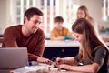 Father Helps Teenage Daughter With Electronics Project Sitting At Kitchen Table At Home With Laptop Royalty Free Stock Photo