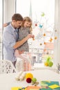 Father and her daughter painting and decorating easter eggs.