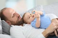 Father and his baby relaxing on a sofa Royalty Free Stock Photo