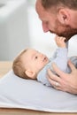 Father and his baby son playing on a changing table Royalty Free Stock Photo