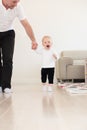 Father and his beautiful baby girl playing and learning how to walk. Royalty Free Stock Photo