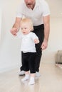 Father and his beautiful baby girl playing and learning how to walk. Royalty Free Stock Photo