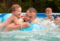 Father and his children having fun in the pool Royalty Free Stock Photo