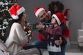 Father with his cute son presenting gift to mother at home. Christmas celebration Royalty Free Stock Photo
