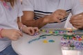 Father with his daughter making beaded jewelry at table, closeup Royalty Free Stock Photo