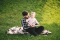 Father and his little baby daugter reading book in a park