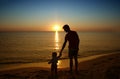 Father and his little baby son stay together on sunset beach. Fa Royalty Free Stock Photo