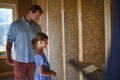 Father with his little daughter checking their unfinished wooden house, diy eco-friendly homes concept. Royalty Free Stock Photo