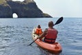 A father and his little daughter are sailing on the sea in a kayak to a grotto Royalty Free Stock Photo