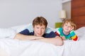 Father and his little kid son relaxing and resting in white bed Royalty Free Stock Photo